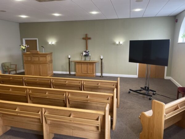 A respectful visual display setup showing a memorial photo slideshow inside a celebration venue.