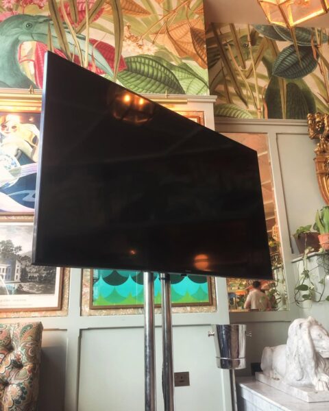 65 inch display screen mounted on a heavy duty stand inside a Cardiff hospitality venue.