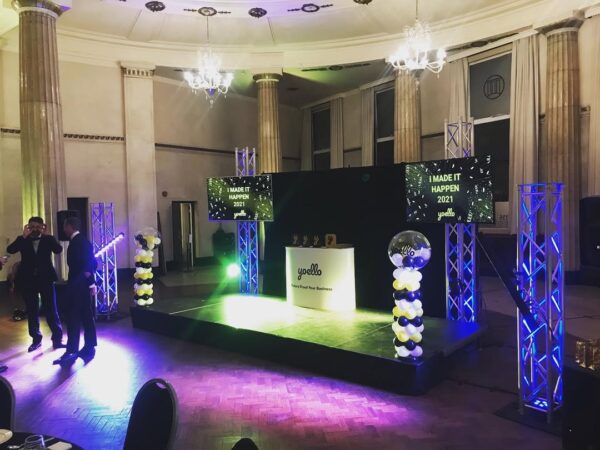 Multiple 4K TV screens linked together displaying synchronized presentation content across a large venue.